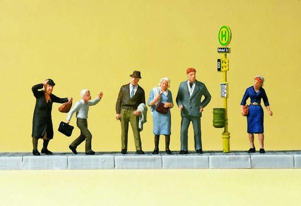 Voyageurs debouts à l'arrêt de bus